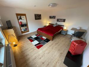 ein Schlafzimmer mit einem roten Bett und einem roten Koffer in der Unterkunft Ferienhaus Rheinnähe in Lykershausen
