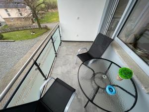 balkon ze stołem, 2 krzesłami i oknem w obiekcie Ferienhaus Rheinnähe w mieście Lykershausen