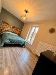 a bedroom with a bed and a window at Les Deux L du Vignoble in Chablis +7 photos