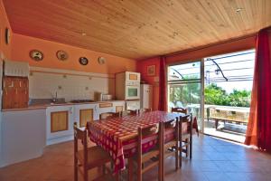 a kitchen and dining room with a table and chairs at Maison 9 couchages avec piscine et jardin au calme in Barbaggio