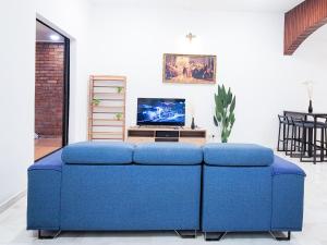 un divano blu in soggiorno con TV di OUG8 Garden Home BBQ Karaoke a Kuala Lumpur