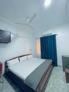 1 dormitorio con 1 cama grande y cortina azul en Nana's Holiday Let, en Accra