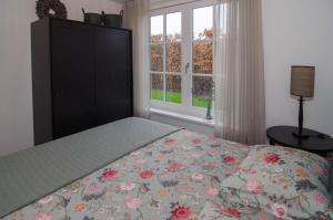 1 dormitorio con 1 cama, vestidor y ventanas en B&B de Plattelandshoeve, en Rhenen