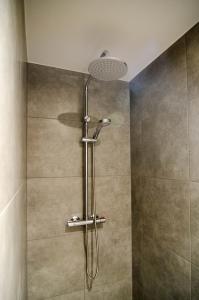 a shower with a shower head in a bathroom at B&B de Plattelandshoeve in Rhenen