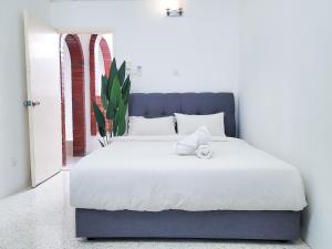 una camera da letto con un grande letto con lenzuola bianche di OUG8 Garden Home BBQ Karaoke a Kuala Lumpur