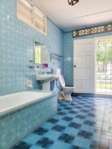 un bagno blu con vasca e lavandino di OUG8 Garden Home BBQ Karaoke a Kuala Lumpur