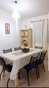 comedor con mesa blanca y sillas en Departamento Aquí & Ahora con aire frio calor en Villa Carlos Paz