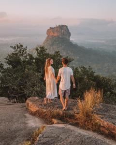 Un uomo e una donna in piedi sulla cima di una montagna di Aliya Resort and Spa - Thema Collection a Sigiriya