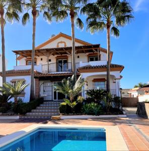 une maison avec des palmiers en face d'une piscine dans l'établissement Casa Limon, boutique Bed and Breakfast, Andalucia, à Alhaurín el Grande