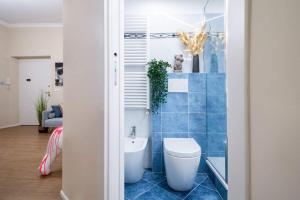 a bathroom with a toilet and a blue tiled wall at My Sweet Home in Genoa