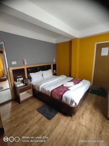 un grande letto in una stanza con pareti gialle di Yakkha Hotel a Darjeeling
