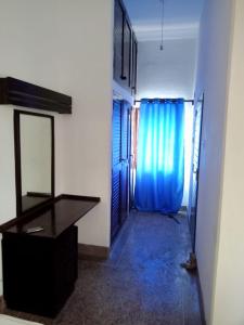 a hallway with a mirror and a dresser and a blue curtain at Halisi Stays 1Bed near SGR/Airport Mombasa in Mombasa