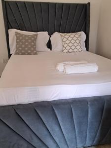 a bed with two towels sitting on top of it at Halisi Stays 1Bed near SGR/Airport Mombasa in Mombasa