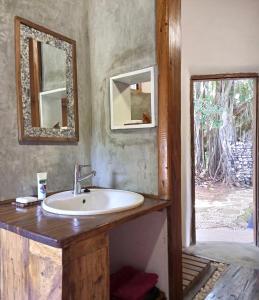 baño con lavabo y 2 espejos en la pared en Belmoz Beach House, 
