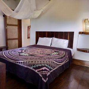 a bedroom with a bed with a blanket on it at Belmoz Beach House in Chuca