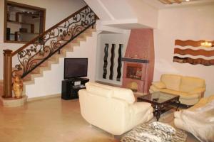 una sala de estar con muebles blancos y una escalera. en Villa zohour, en Marrakech