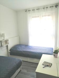 Habitación pequeña con 2 camas y ventana en Apartman Sanja en Pula