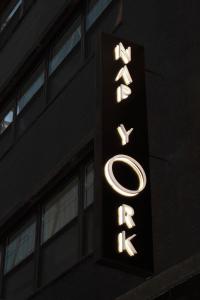 un panneau indiquant un hôtel situé sur le côté d'un bâtiment dans l'établissement Nap York Central Park Sleep Station, à New York