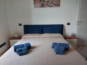 a bedroom with a bed with blue pillows on it at Blue's House in Atrani