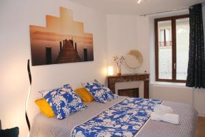 a bedroom with a bed with blue and yellow pillows at Suite avec terrasse, Nancy Thermal, parc Ste Marie in Nancy