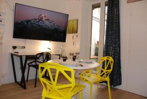 a dining room with a table and yellow chairs at Suite avec terrasse, Nancy Thermal, parc Ste Marie in Nancy