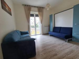 una sala de estar con 2 sofás azules y una ventana en Blue's House, en Atrani