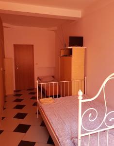 Dormitorio pequeño con cama y nevera en GuestHouse, en Piaseczno