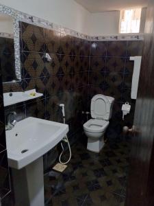 a bathroom with a toilet and a sink at Hotel Sky Inn Clifton in Karachi