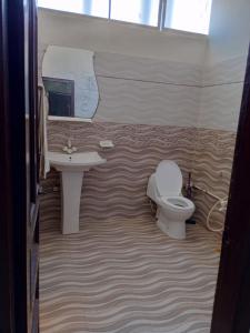 a bathroom with a sink and a toilet at Hotel Sky Inn Clifton in Karachi
