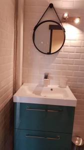 łazienka z umywalką i lustrem na ścianie w obiekcie Le Viva w mieście Saint-Étienne