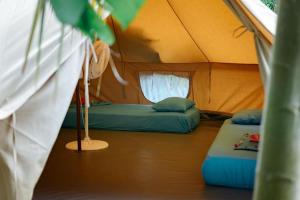a room with two beds in a tent at Rio Hostel Buritaca in Buritaca