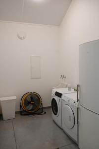 a laundry room with a washing machine and a refrigerator at Landlord in Holsbeek