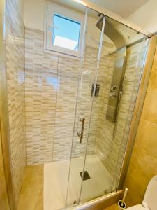 een douche met een glazen deur in de badkamer bij Lucky’s house in Noicattaro