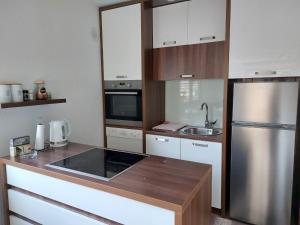 a small kitchen with a stainless steel refrigerator at Apartman Kovaci in Sarajevo