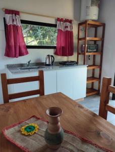 uma cozinha com uma mesa, um lavatório e um balcão em Cabaña en Chascomús cercana a la estación em Chascomús