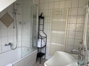 y baño con bañera, lavamanos y ducha. en Am Apfelbaum, ein Ferienhaus zwischen Rhein und Mosel, en Kastellaun