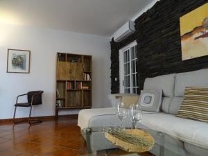 uma sala de estar com um sofá e uma parede de tijolos em BRIGHT AMBIENCE by Stay in Alentejo em Vila Nova de Milfontes