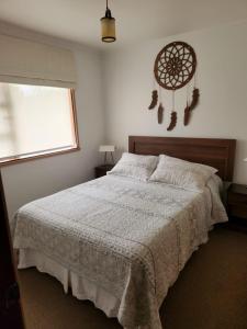 Un dormitorio con una cama grande y una ventana en Cabaña Puerto Varas 1421 en Puerto Varas