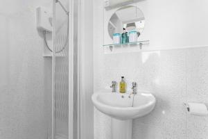 a white bathroom with a sink and a mirror at South view in Torquay +40 photos