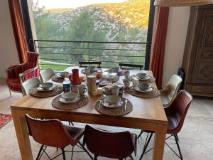 a dining room table with chairs and a large window at AQUARIUS IN CASSIS, Chambres d'Hôtes in Cassis