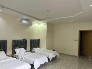 a hospital room with three beds with white sheets at فيلا قمرية الهدا in Al Hada