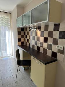 a kitchen with a black counter and a checkered wall at Appartement T3 centre ville in Bastia