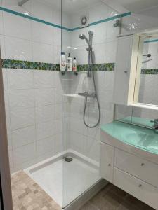La salle de bains blanche est pourvue d'une douche et d'un lavabo. dans l'établissement Appartement T3 centre ville, à Bastia