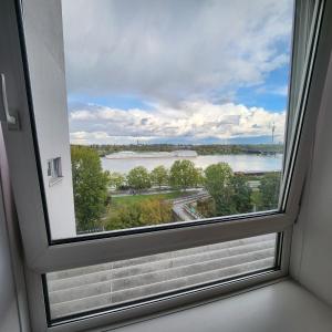 een raam in een kamer met uitzicht op een meer bij Lovely Apartment for 4 on the Danube River - Private Parking in Wenen