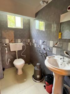 a bathroom with a toilet and a sink at Hiddenvalley Stays - Riverside in Madikeri