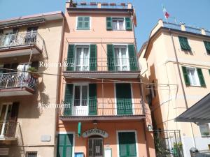 d'un grand bâtiment avec des fenêtres et des balcons à volets verts. dans l'établissement Ca de Gianchi - Verdeblù, à Manarola