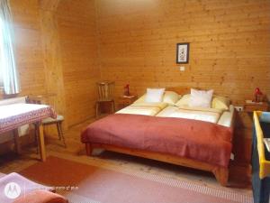 - une chambre avec un lit dans une pièce en bois dans l'établissement Rauter in Wöllan, à Arriach