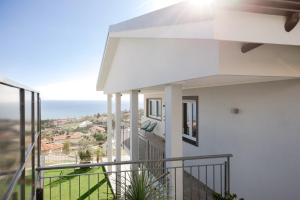 uma casa branca com uma varanda com vista para o oceano em Villa la Matta em Sanremo