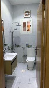 La salle de bains blanche est pourvue de toilettes et d'un lavabo. dans l'établissement فيلا قمرية الهدا, à Al Hada