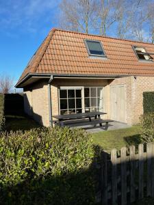 ein Haus mit einer Bank davor in der Unterkunft Casa Vista Verde in De Panne